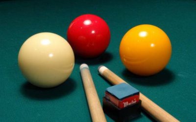 Biljartballen en keu op groene tafel